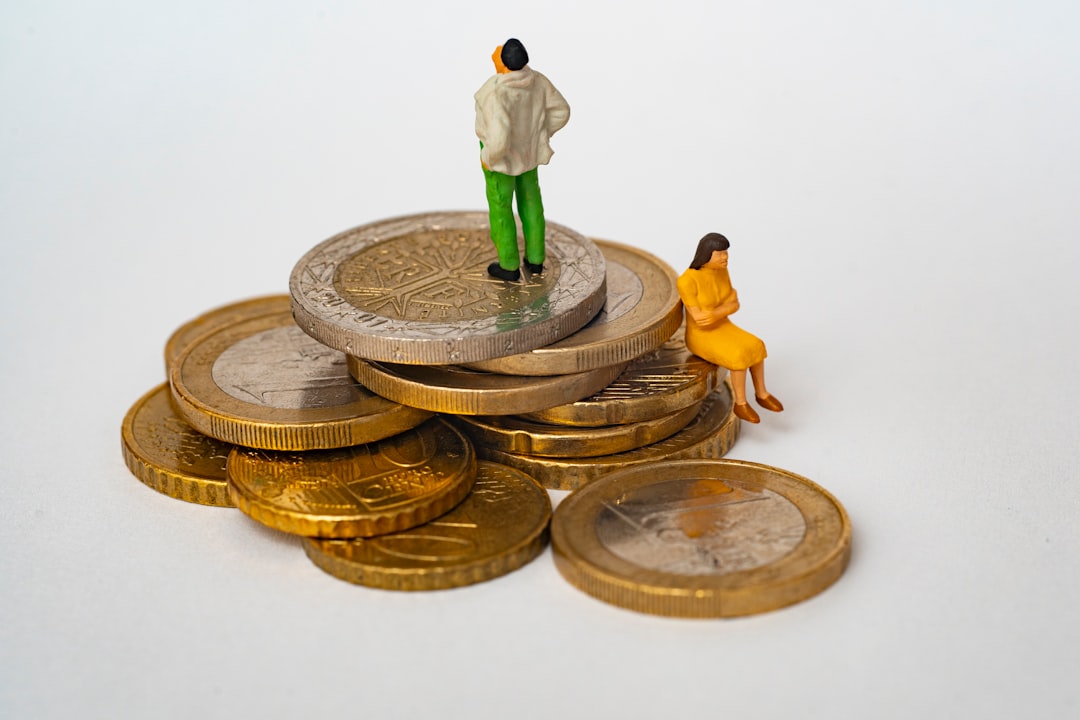 A miniature man and woman on a stack of gold and silver coins