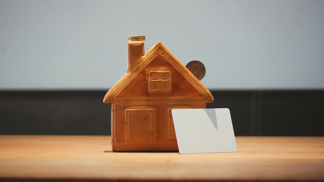 A small house bank with a coin and blank card