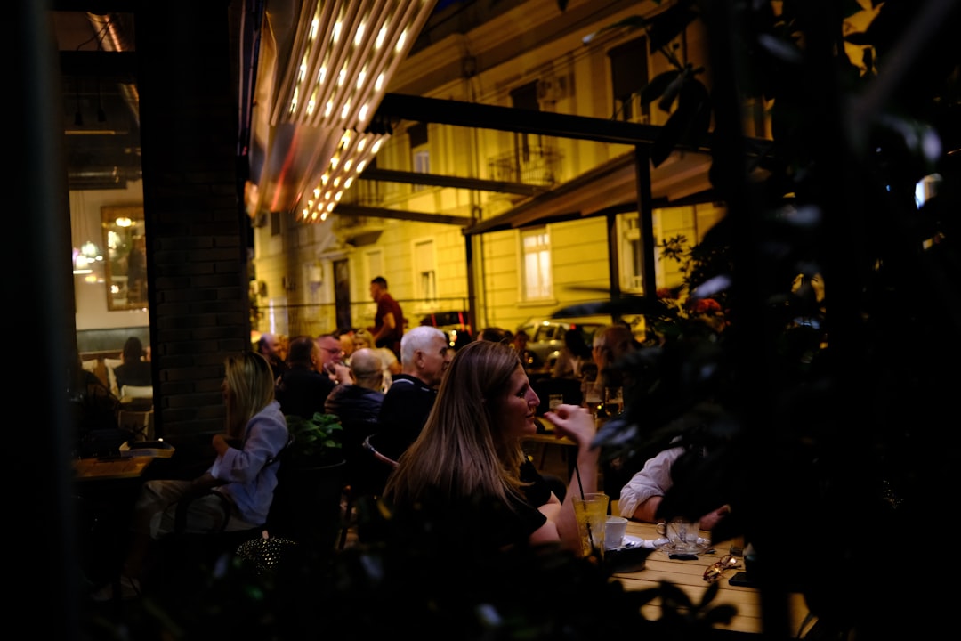 People enjoying an evening meal at a lively outdoor restaurant.