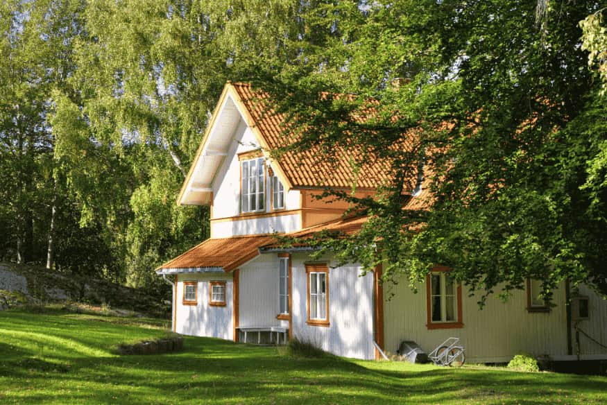 Casa de campo moderna com fachada de madeira e amplas janelas para integração com a natureza.