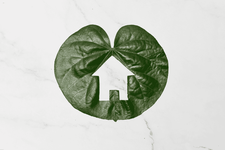 Símbolo de casa ecológica feito a partir de uma folha verde representando sustentabilidade.