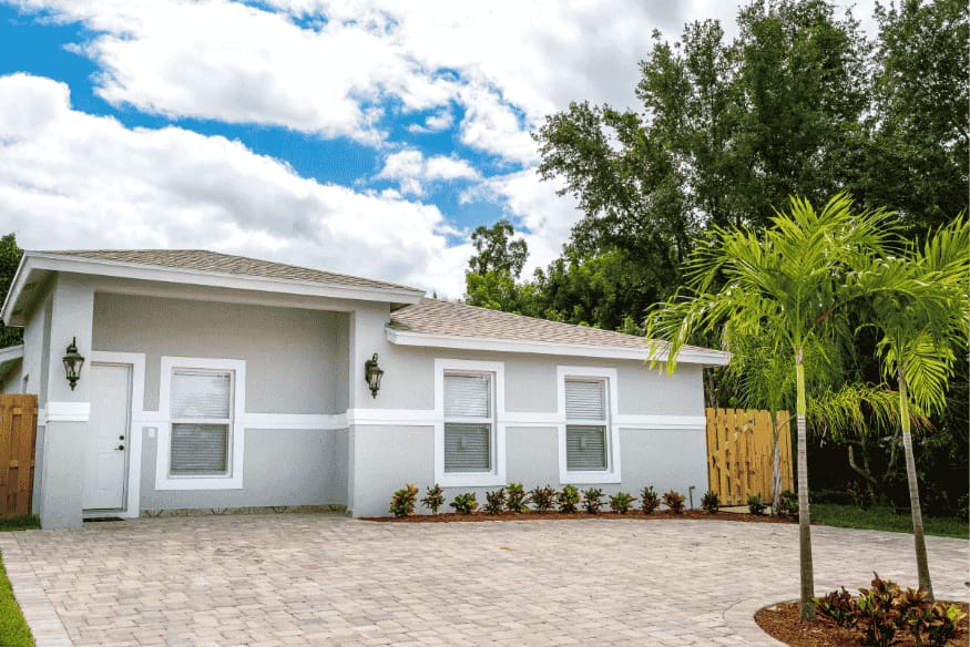 Casa térrea moderna com fachada clara, telhado simples e jardim frontal minimalista.