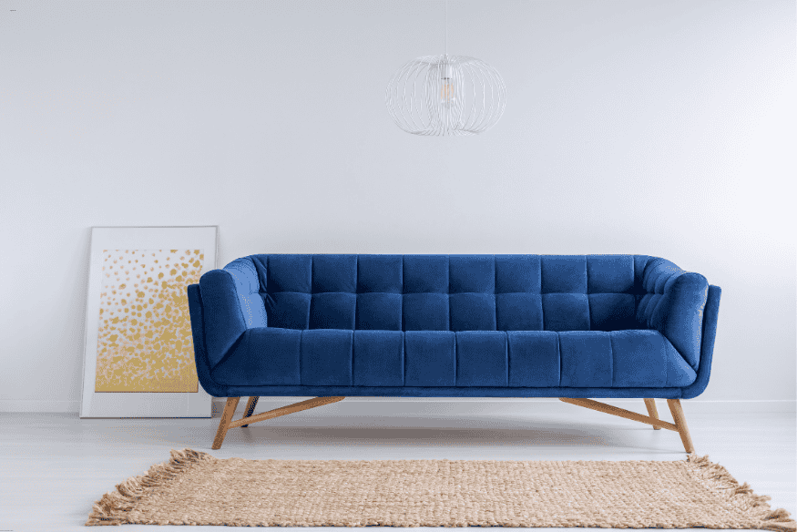 Sala com sofá azul e tapete de fibras naturais destacando o contraste na decoração.
