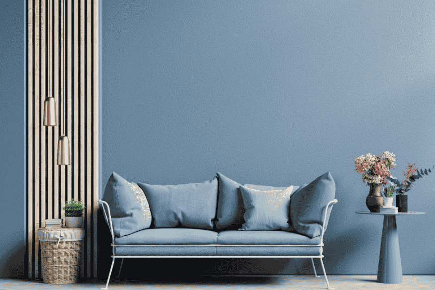 Sala de estar com sofá azul e parede azul, tendência de cor para 2025.