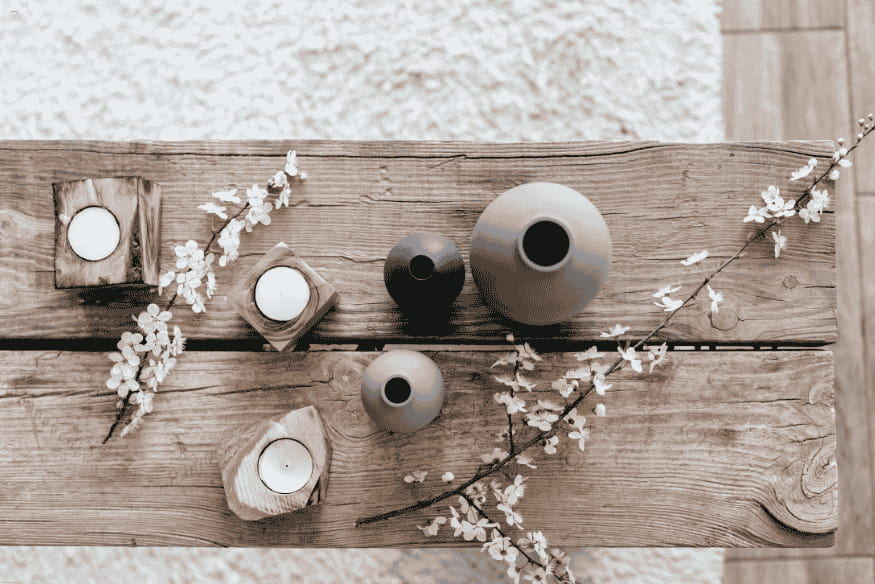 Mesa rústica com velas e vasos pequenos no estilo escandinavo.