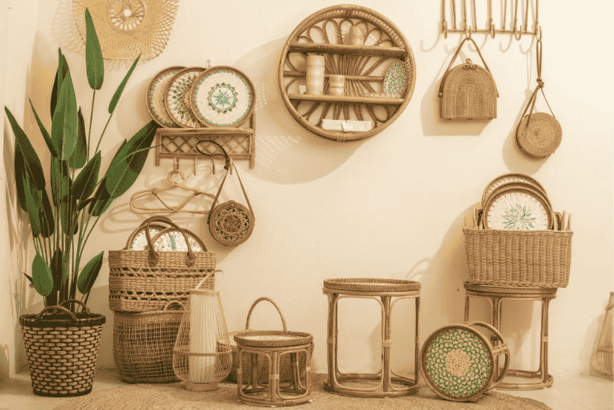 Decoração boho com móveis e acessórios de vime, pratos decorativos e plantas naturais.