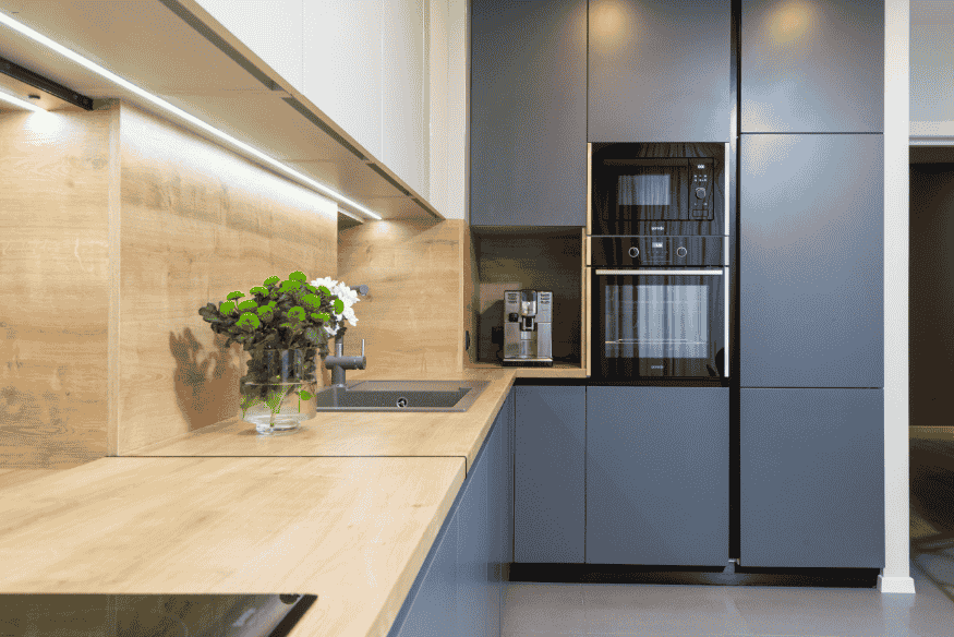 Cozinha planejada moderna com eletrodomésticos embutidos e iluminação em LED.