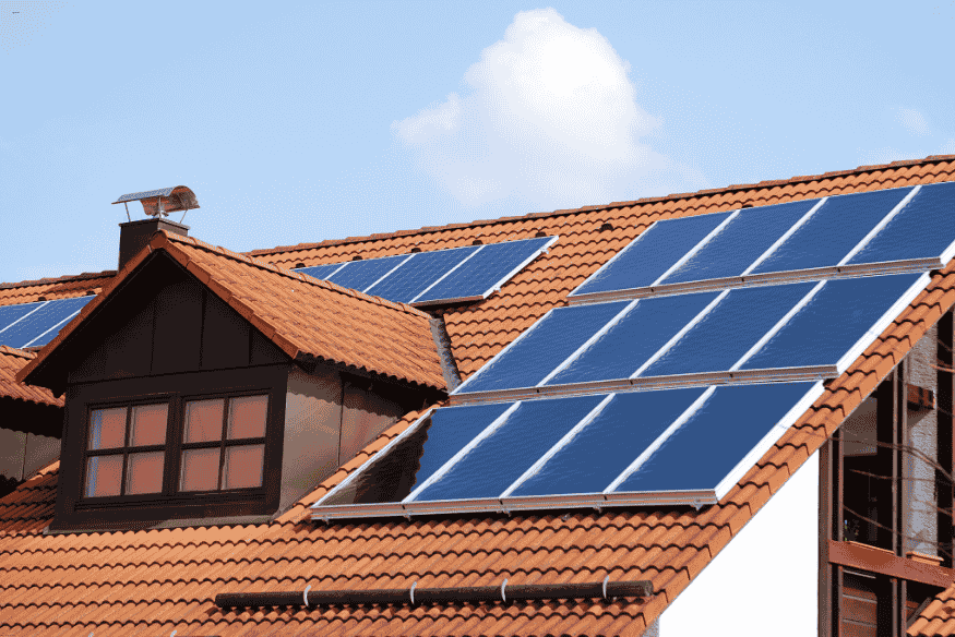 Casa residencial com telhado coberto por painéis solares para geração de energia elétrica.