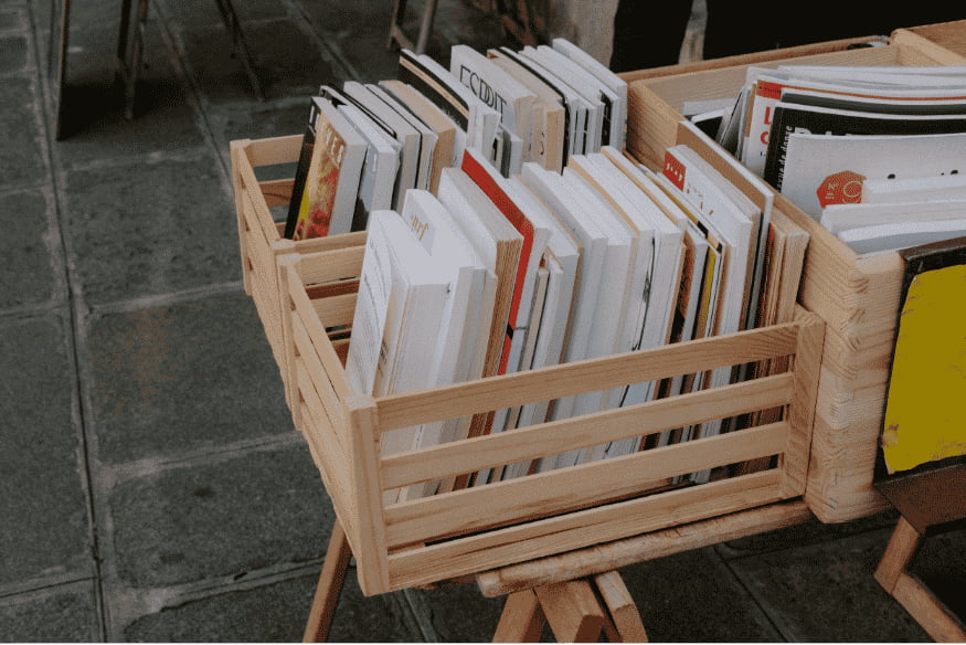 Caixotes de madeira usados como estante para livros e revistas.