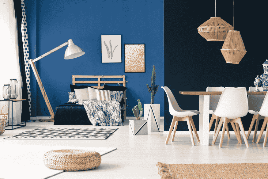 Ambiente integrado com quarto e sala de jantar usando móveis multifuncionais.