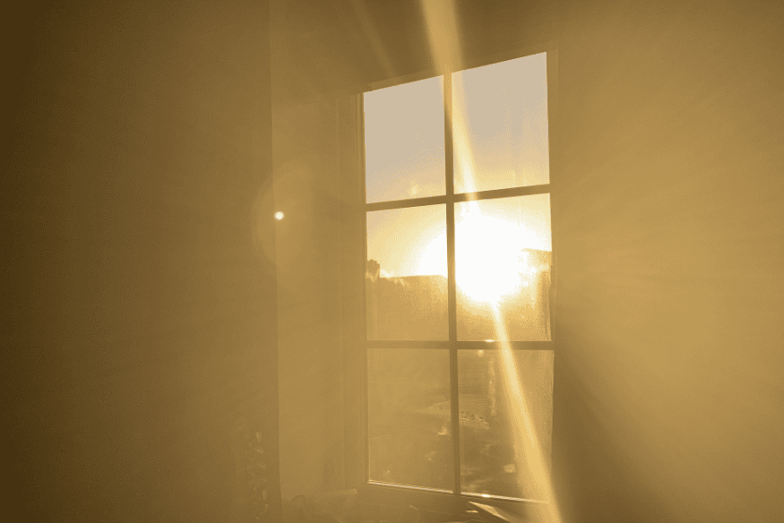 Sol entrando por janela retangular, iluminando o interior da casa.