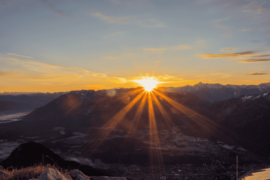 Nascer do sol sobre montanhas, simbolizando a importância da orientação leste em projetos residenciais.