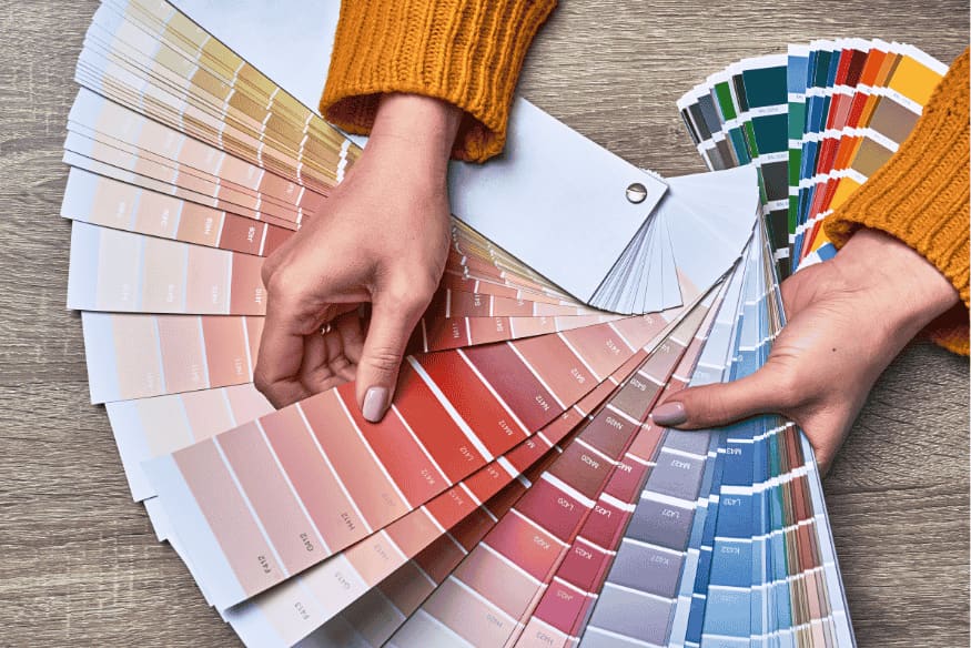 Seleção de paleta de cores usando leque de amostras para decoração residencial.