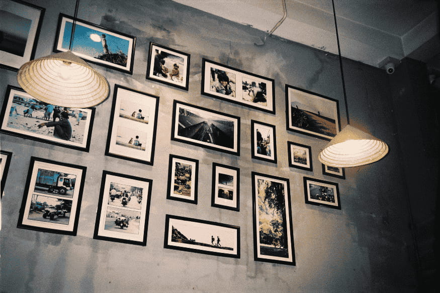 Galeria de quadros em parede cinza com iluminação pendente moderna