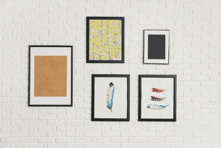 Parede de tijolos brancos com quadros decorativos modernos coloridos