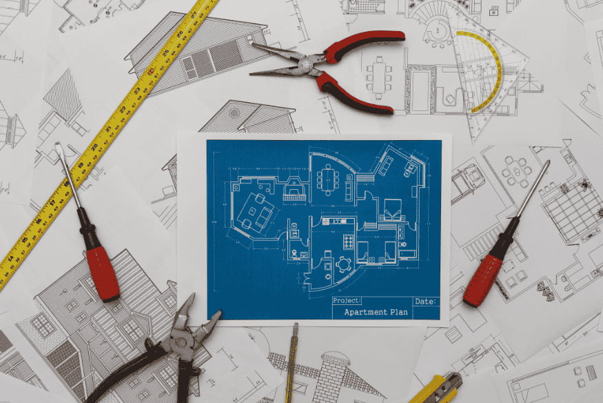 Planta arquitetônica com ferramentas de medição e projeto de apartamento.