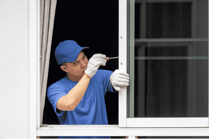 Profissional instalando janela de alumínio durante reforma residencial.