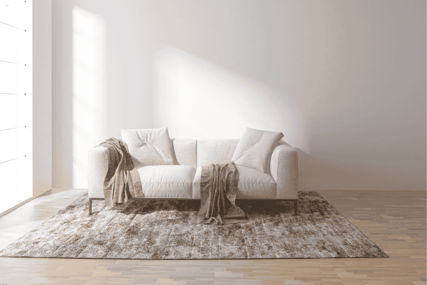 Sofá branco sobre tapete texturizado marrom em sala iluminada por luz natural.