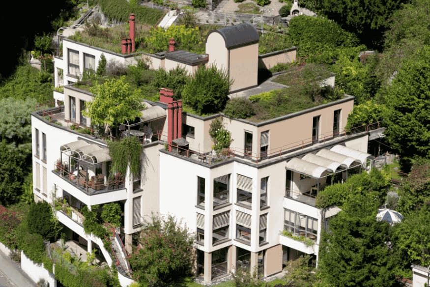 Prédio residencial com múltiplos telhados verdes e jardins integrados à arquitetura.
