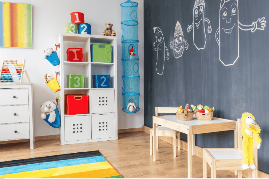 Quarto infantil com parede pintada com tinta lousa para desenhos.